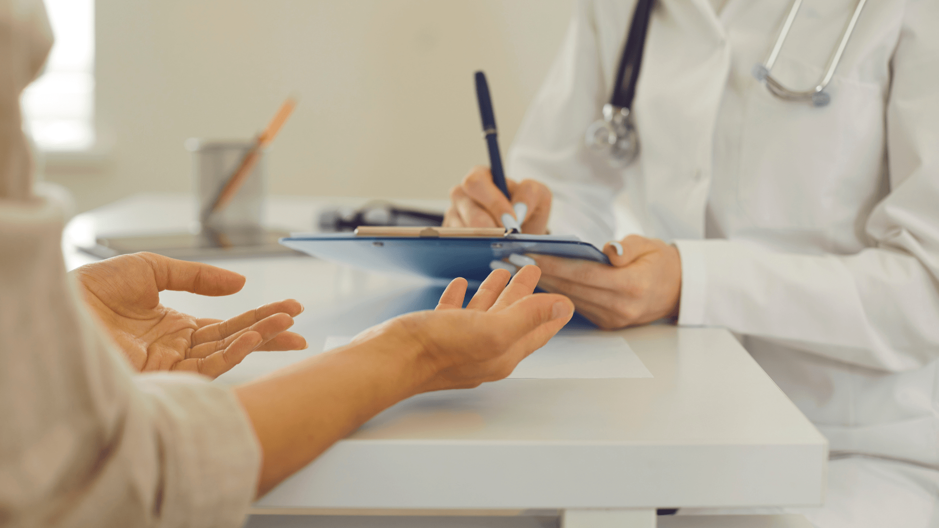 DOCTOR TAKING NOTES WITH PATIENT